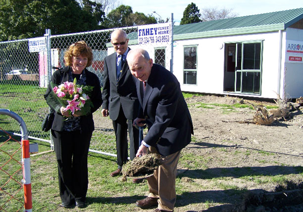 Peter Adams, son of Ernest Adams, ceremoniously turns the earth, watched by Jessica Adams and Board Chair, Dr John Musgrove.